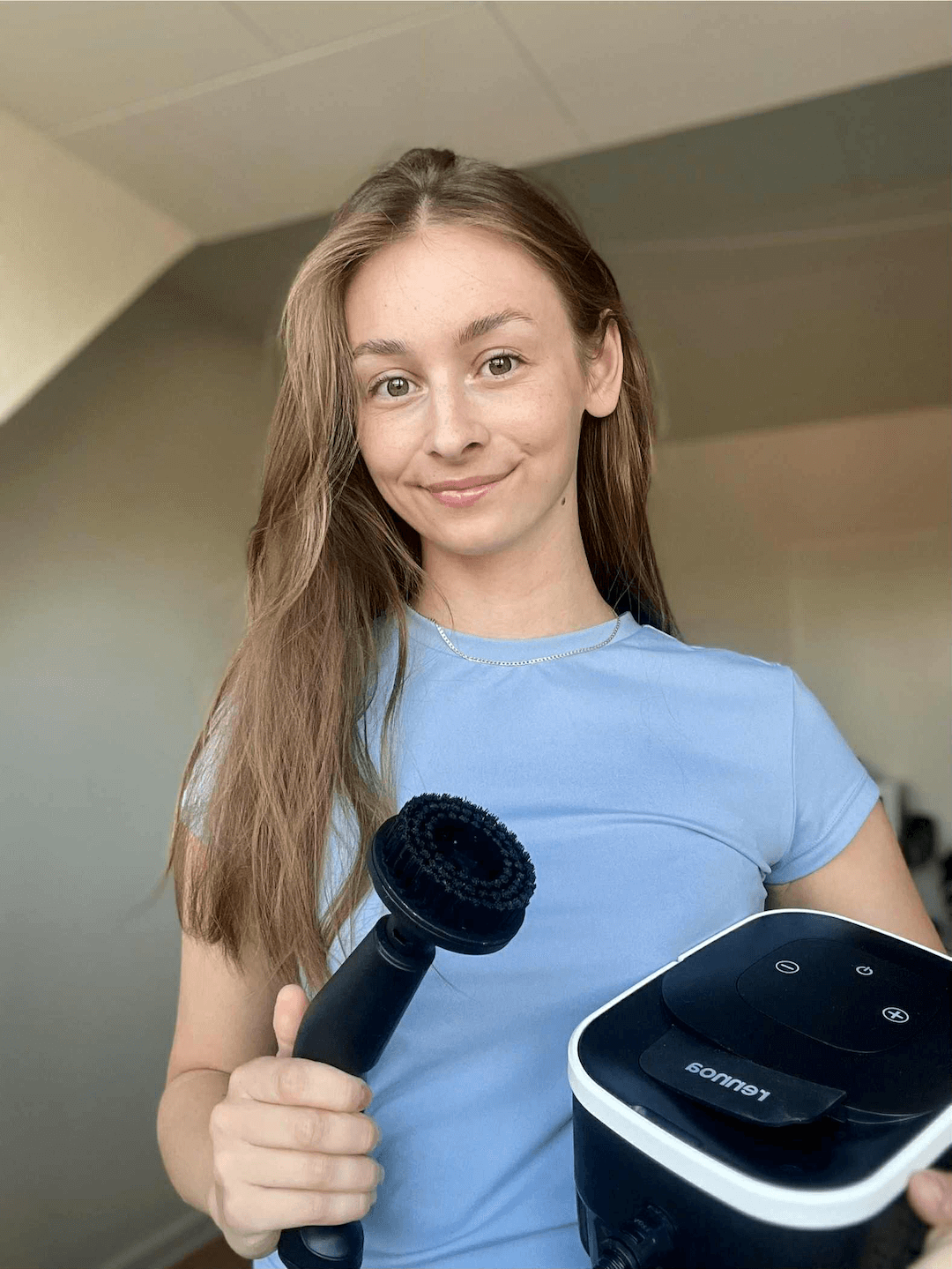 Person holder Rennoa damprenser med børstemundstykke – klar til effektiv rengøring